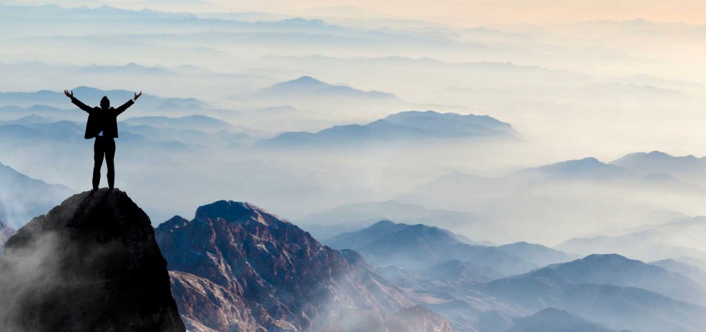 victorious person standing on top of mountain after conquering keratoconus